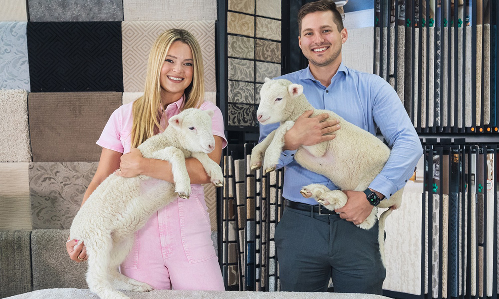 Lauren and Jack Coles holding baby lambs in coles fine flooring store